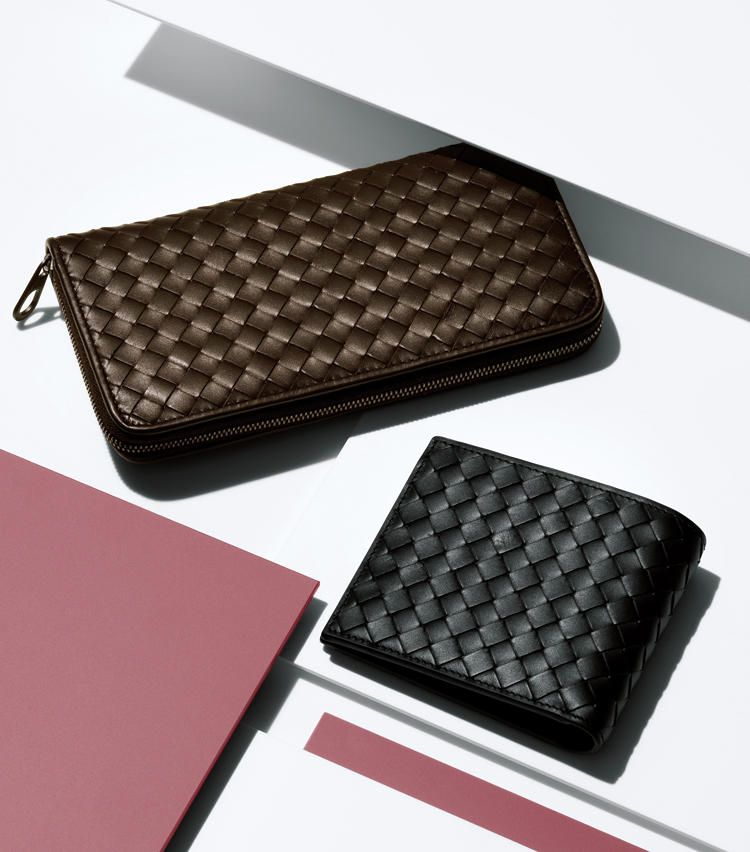 <span style=font-size:1.1em;><strong>BOTTEGA VENETA</strong></span><br /><strong>ボッテガ・ヴェネタのイントレチャート</strong><br /><br /><strong>クオリティを物語るのはロゴではなく技術力</strong><br />ロゴを一切使わないのに、ブランドを雄弁に物語る。それがボッテガ・ヴェネタの十八番とするイントレチャートの革小物だ。こちらはカーフレザーに短冊状に切れ込みを入れ、1本1本適切なテンションを保ちながら編み込んだもの。そこには門外不出の技術も潜んでおり、継承のため同社は職人養成の学校も備えるほど。その妥協を許さない姿勢は、しっとり滑らかなタッチや、独特のラグジュアリーな風格に表れている。職人を大事にするイタリアの精神風土すら感じさせる逸品だ。<br /><span style='font-size:0.8em;'>左：ラウンドジップ財布。縦10×横19cm。8万7000円 右：二つ折り財布。縦9.5×横11cm。5万1000円（以上ボッテガ・ヴェネタ　ジャパン）</span>