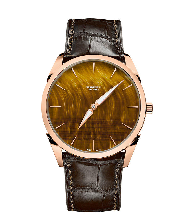 <b>PARMIGIANI FLEURIER</b>　パルミジャーニ・フルリエ　トンダ 1950<hr style='margin-bottom:20px'><b>天然石で一層際立つ黄金比による造形美</b></br>金褐色に煌めく細かな縞模様を浮かべるダイヤルは、天然石のタイガーズアイ製。ダイヤルもケースも、すべてのディテールは黄金比に基づいて設計される。極めて美しい外装に包まれたマイクロローターによる薄型自動巻きも、職人の手業で美観を極めている。限定50本。自動巻き。径39mm。18KRGケース。アリゲーターストラップ。305万円（パルミジャーニ・フルリエ）