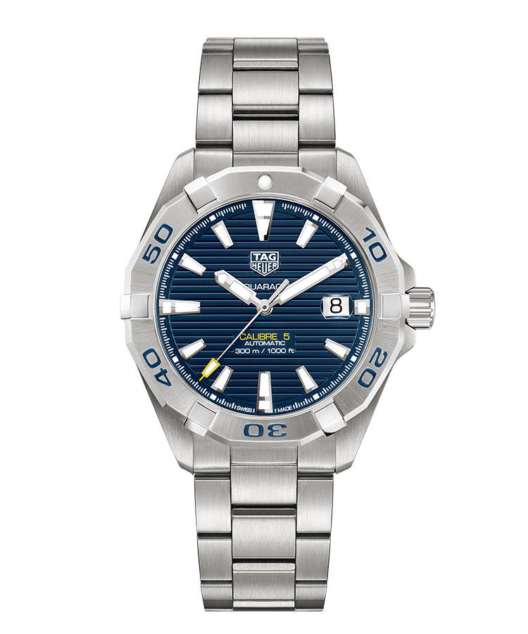 <b>TAG HEUER</b>　タグ・ホイヤー</br><b>アクアレーサー キャリバー5</b><hr style='margin-bottom:20px'><b>スタイリッシュなモダン・ダイバーズ</b></br>丸いケースに12角形の逆回転防止ベゼルを組み合わせ、モダンなダイバーズウォッチへと仕立て上げた。そのベゼルには6つのタブが与えられ、操作性も高めている。ダイヤルのブルーが色鮮やか。わずかに差したイエローが絶妙なアクセントとなった横ストライプ装飾も、スタイリッシュだ。自動巻き。径41mm。SSケース＆ブレスレット。23万円（LVMH ウォッチ・ジュエリー ジャパン タグ・ホイヤー）