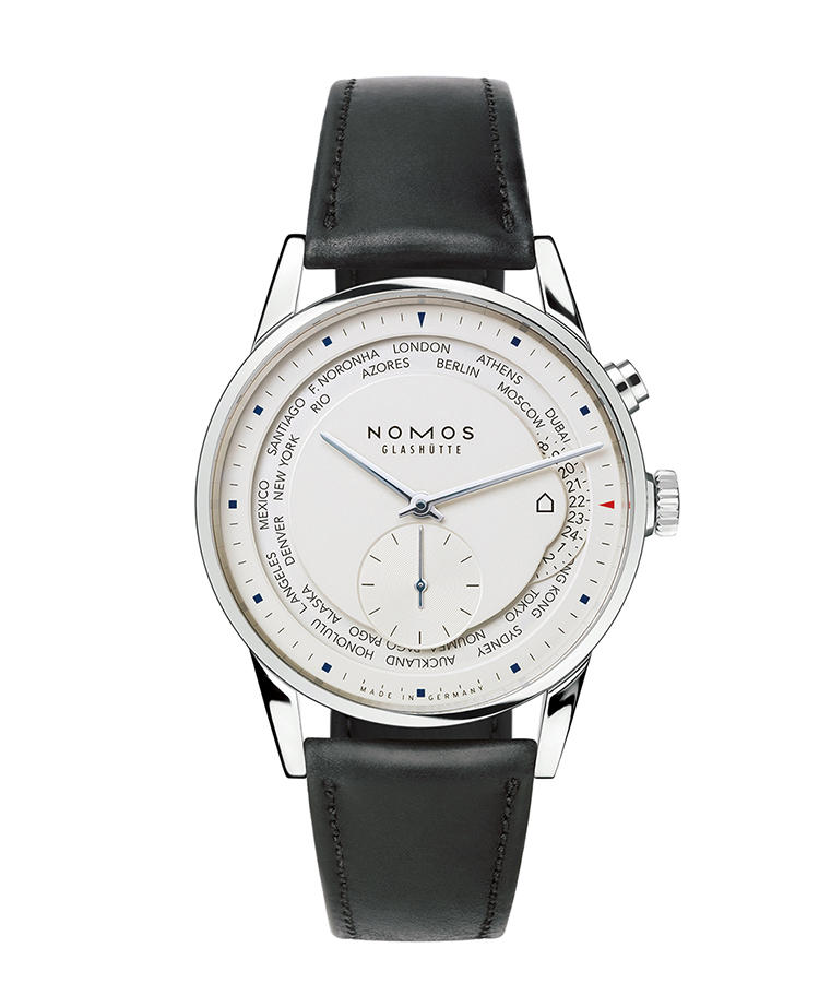 <b>NOMOS GLASHUTTE</b> ノモス グラスヒュッテ</br><b>チューリッヒ・ワールドタイマー</b><hr style='margin-bottom:20px'><b>バウハウス仕込みのシンプリシティ</b></br>2時位置のボタンを押すと、都市名リングは左回りに、時針は右回りに1つずつ移動。12時位置にある都市名の現在時刻を、時分針が示す。3時位置に都市名リングと重ねるように配したディスクは、24時間表記のホームタイム表示。その横に家のマークを添えて、機能を伝えているのが、ノモスらしい。自動巻き。径40mm。SSケース。シェルコードバンストラップ。67万円(大沢商会)