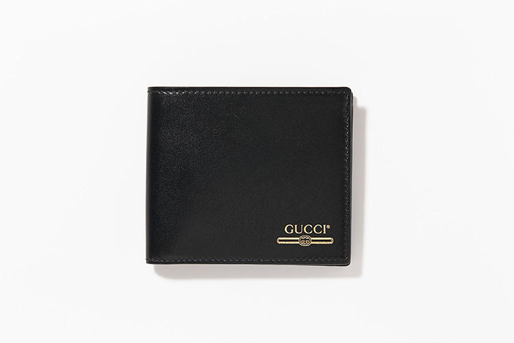 <strong>GUCCI</strong><br />ブラックのスムースレザーにあしらわれるゴールドの箔押しロゴは、'80年代のヴィンテージプリントにインスピレーションを得たもの。縦9cm×横11cm。5万5000円／グッチ（グッチ ジャパン）