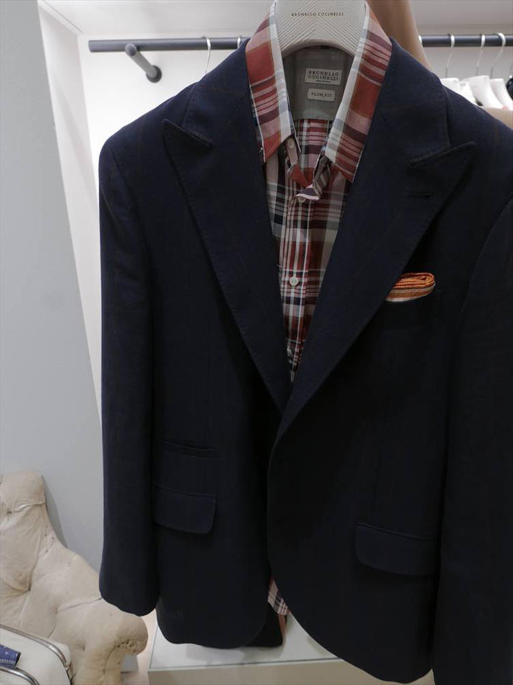 <strong>BRUNELLO CUCINELLI</strong><br />シンプルな紺ジャケットをノータイで着崩すとき、カラフルなマドラスチェックシャツでメリハリを出すテク。秋口にも応用できそう。