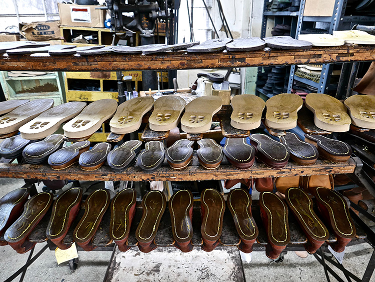 <p>Boots dry on a rack for one day after being soaked in water and having the vamps pulled up and tacked to the last.  When the leather dries it will form perfectly to the custom last.<br />
水に浸し、つま革を木型に合わせて引き伸ばした後、ラックの上でブーツを丸一日乾かします。革が乾く際に、完璧に木型に沿って形ができあがります。</p>
