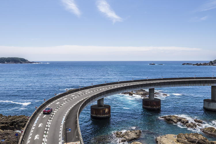 <p>大島へと至るループ橋。真っ青な海とマクラーレンGTの赤とのハイライトが美しい。</p>
