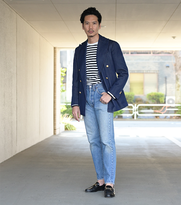 <p>Nishiguchi-san coordinates a Stile Latino double breasted jacket and an Agnes B. border T-shirt, against a pair of just-fitting 66 “Early Period” model jeans. This is mix style in Nishiguchi’s fashion, weaving in old items and new. “I pair blue items a lot with faded jeans,” is how he puts it. While it is a simple outfit that narrows down the number of colors, the unique appearance of the vintage jeans brings out an impressive elegance. </p>
