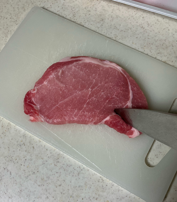 <p>1. 豚肉は水分を拭き取り、脂身と肉の境目を筋切りをし、包丁の背で全体を軽く叩いておく。</p>
