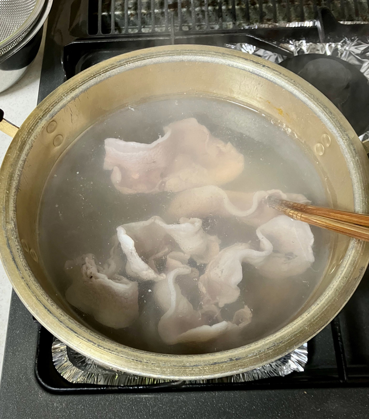 <p>2. 大きめの鍋にたっぷりと湯を沸かす。火を止め、豚肉を広げながら湯に入れる。</p>
