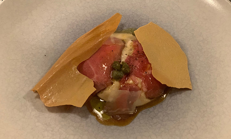 <p>「宮古島産ピンザのロースト　トンナートソース」。ピンザとは、宮古方言で「ヤギ」の意。ヤギ肉というと、通常は臭みがありそうな印象があるが、宮古のヤギは臭みなく育つのが特徴で、このロースト肉とトンナート（ツナのソース）が抜群のマリアージュを見せる。</p>
